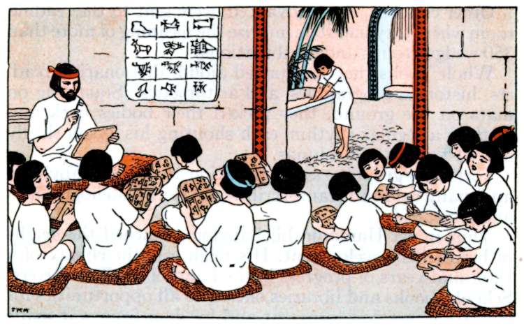 Students lookat at tables and talk while a teacher instructs. They are all wearing white gowns and they sit on the ground