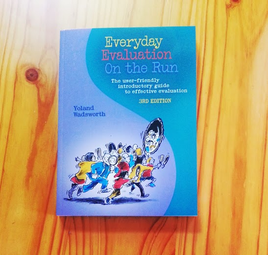 Cover of the book Everyday Evaluation on the Run shows a drawing of people holding up magnifying glasses in front of a large mirror