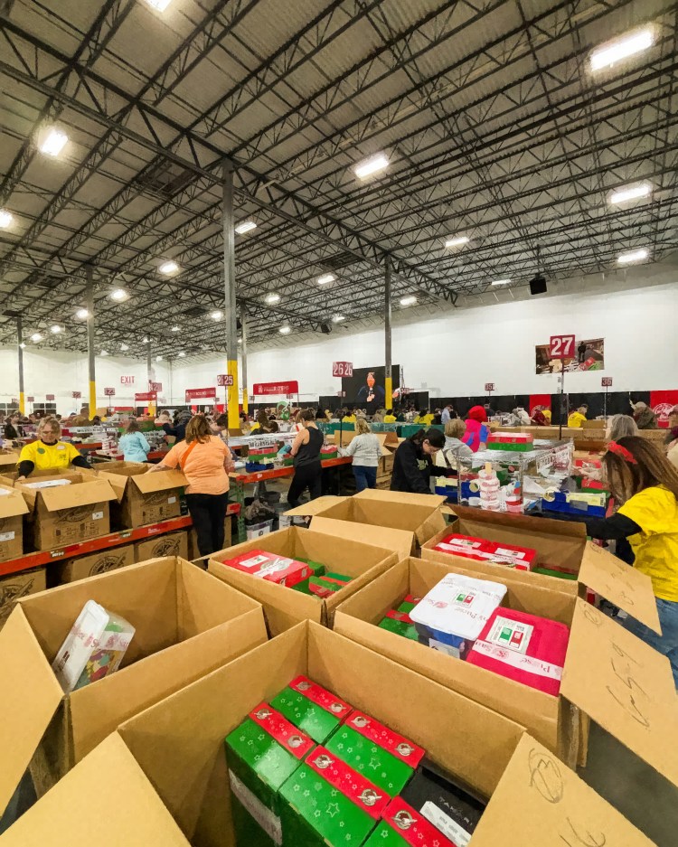 Volunteers pack large boxes in a warehouse