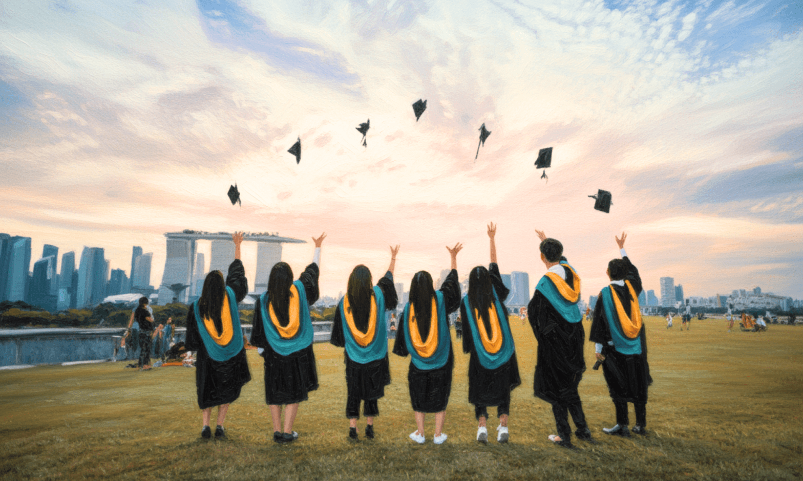Students in graduation robes throw their caps in the air