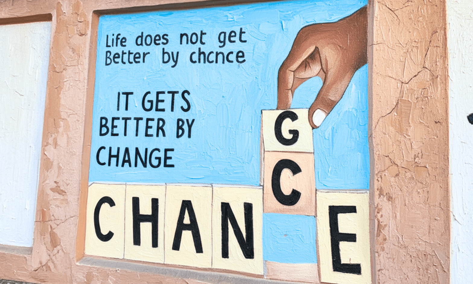 Mural with street art. Shows a Black person's hand changing the letter 'C' in the word 'Chance,' with a 'g,' so it reads 'Change.