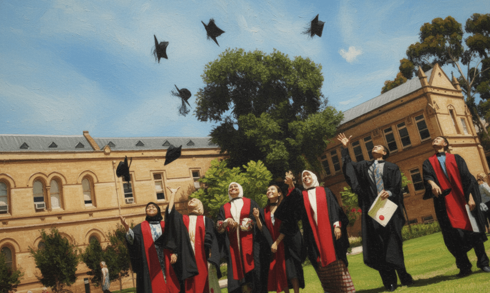 Seven students smile and throw their graduation caps in the air, four of the women are in hijab