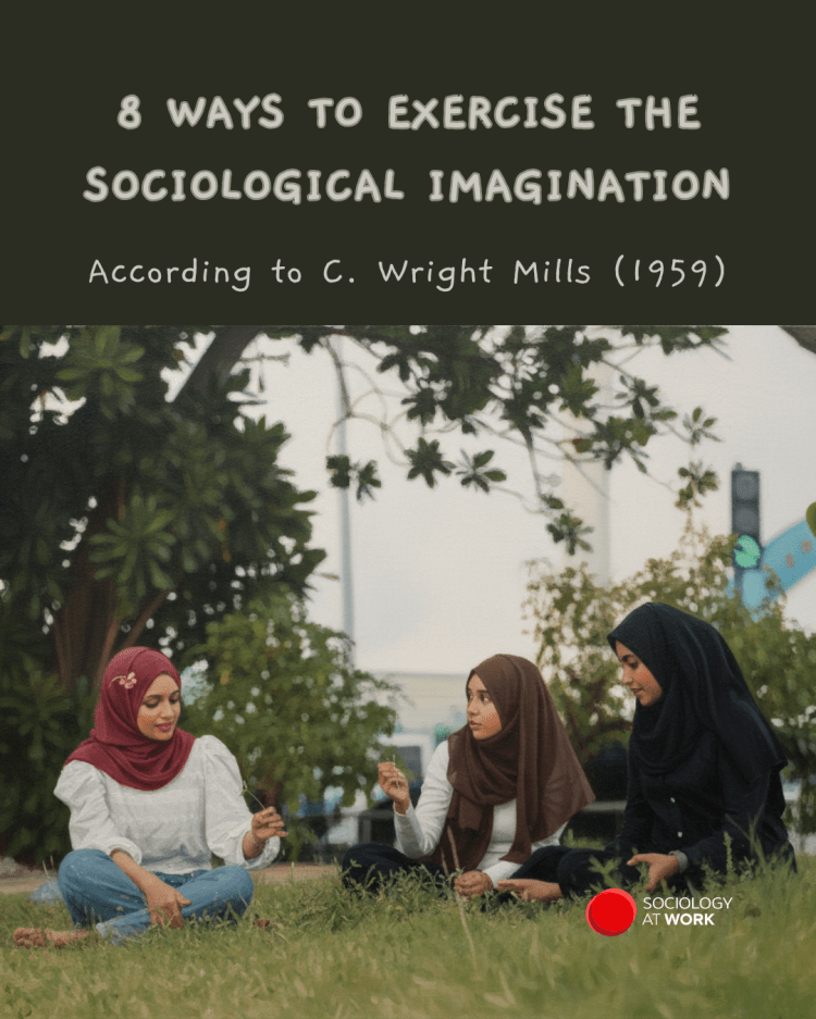 Three young women in hijab sit on grass outdoors holding flowers while talking